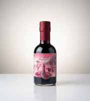 Bottle of red wine with a pink label on a white background