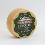 Round cheese with a green label on a white background