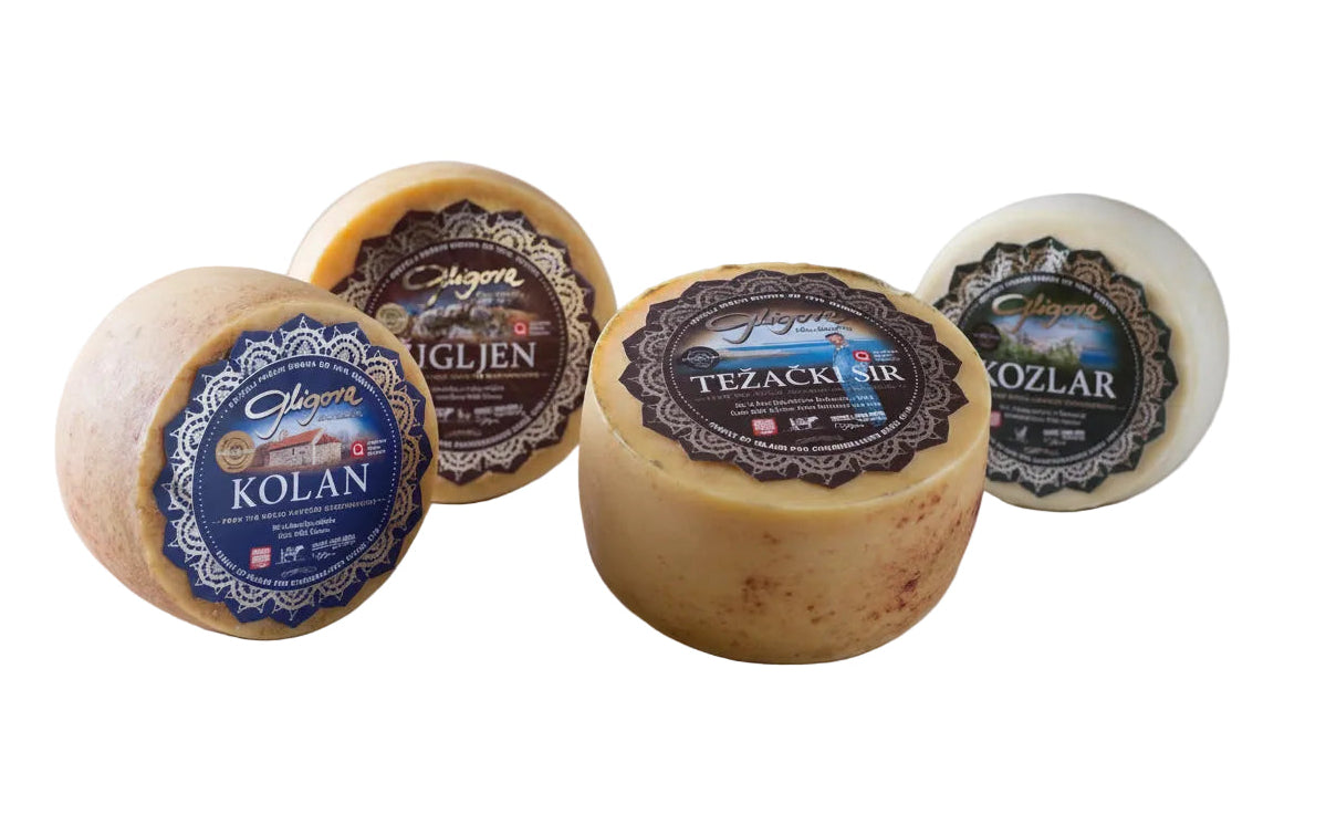 Assorted cheeses with labels on a wooden surface