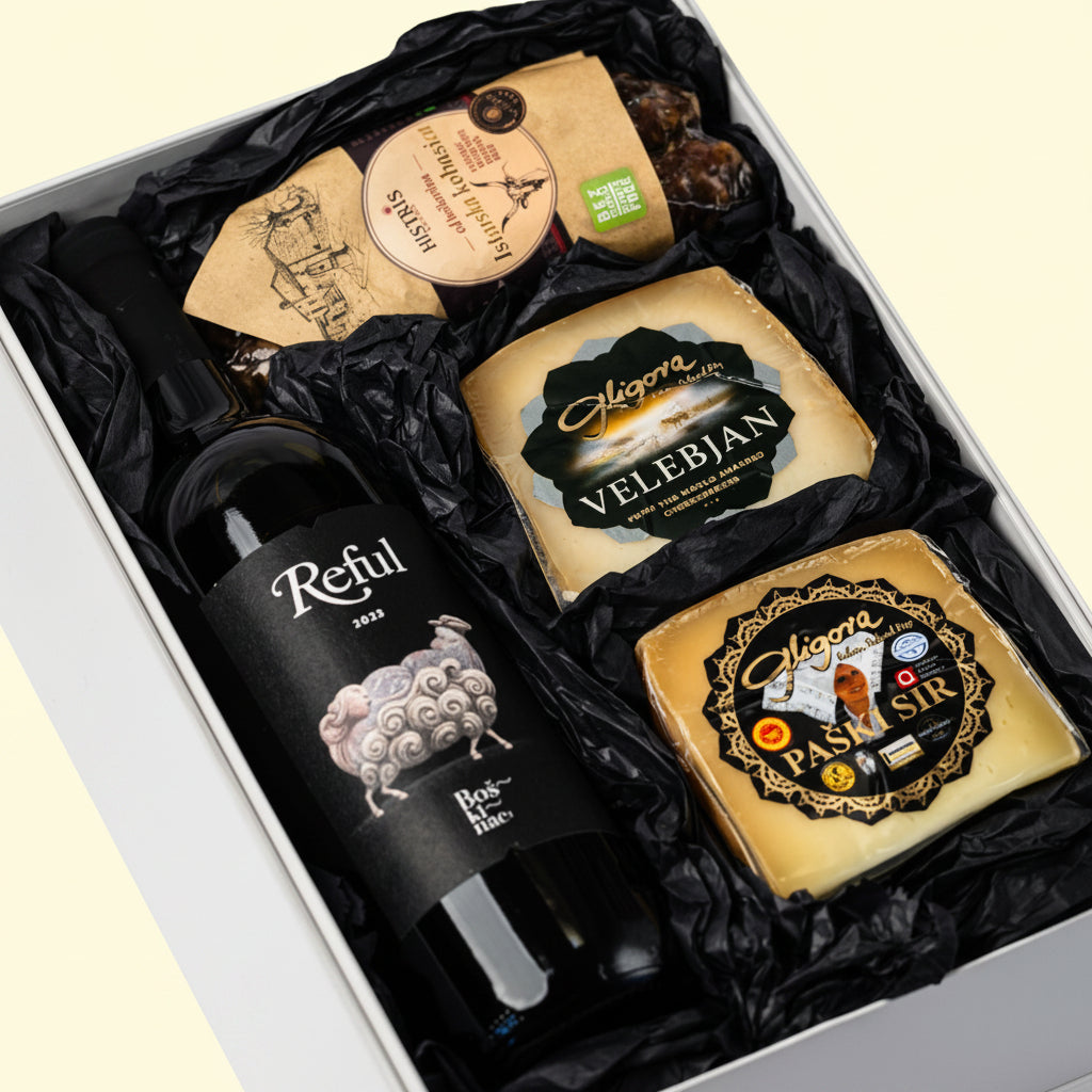 Bura premium gourmet gift box by Gligora featuring Pag cheeseVelebjan cheese, cured Histris Boškarin sausage, and a bottle of Boškinac Reful premium red wine inside an elegant black magnetic box. 