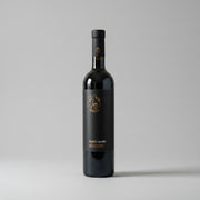 Black wine bottle with gold label on a white background