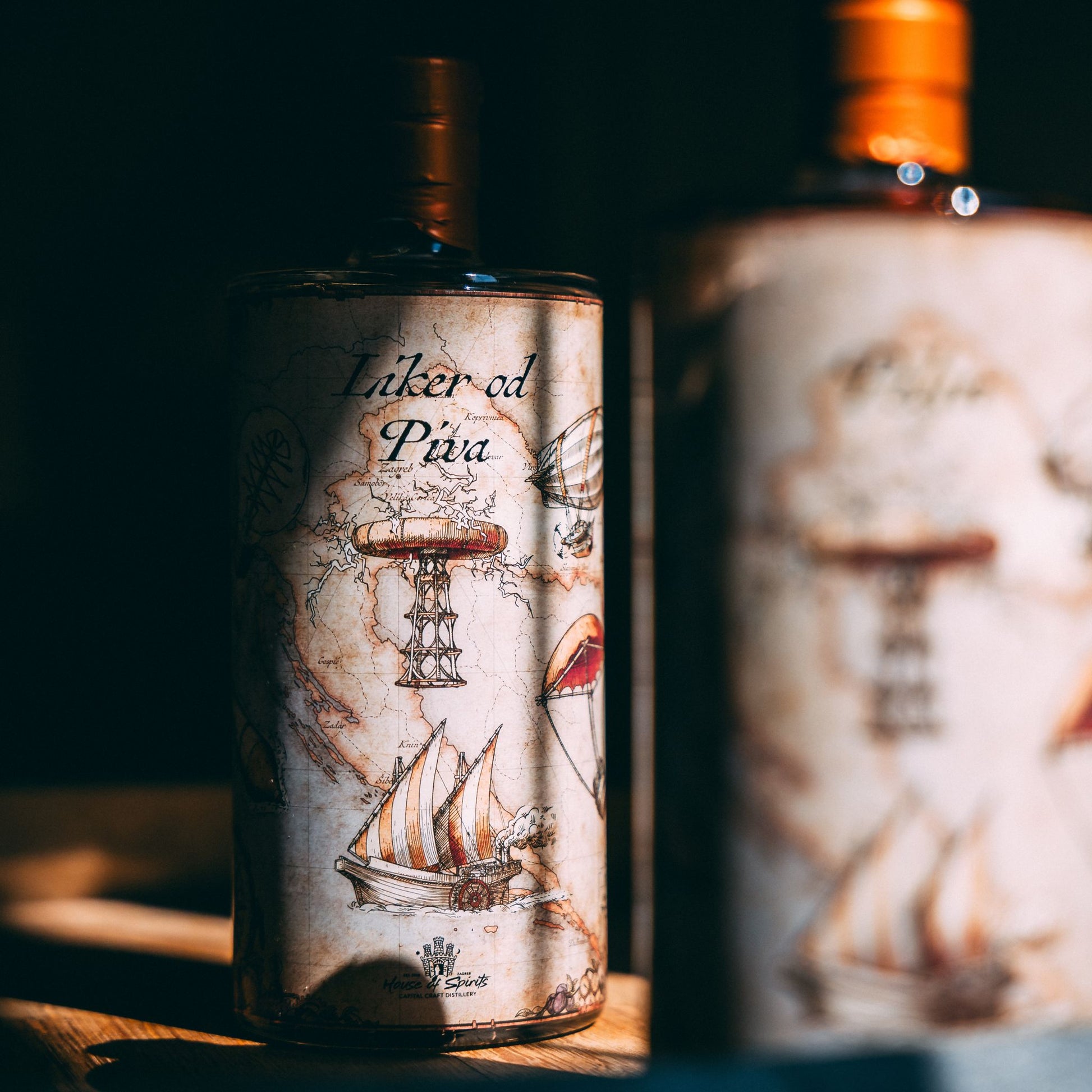 Alcohol bottle with decorative label featuring a ship and map design on a wooden surface.