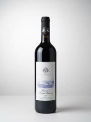 Red wine bottle with a label on a white background