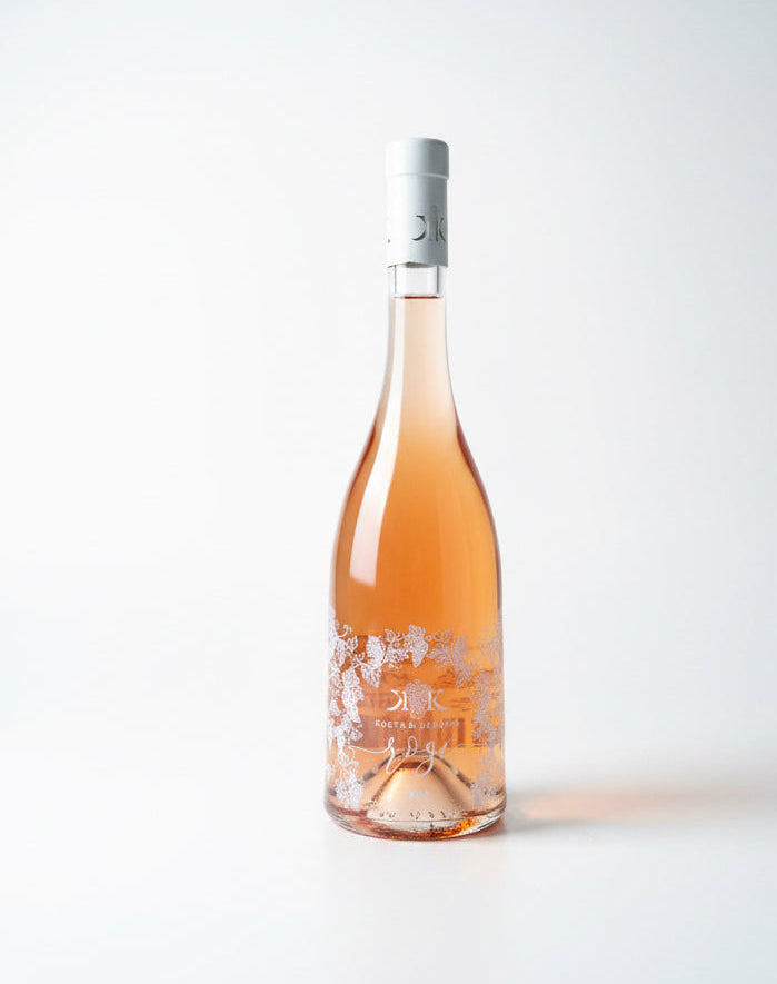 Bottle of rosé wine with a white label on a light gray background