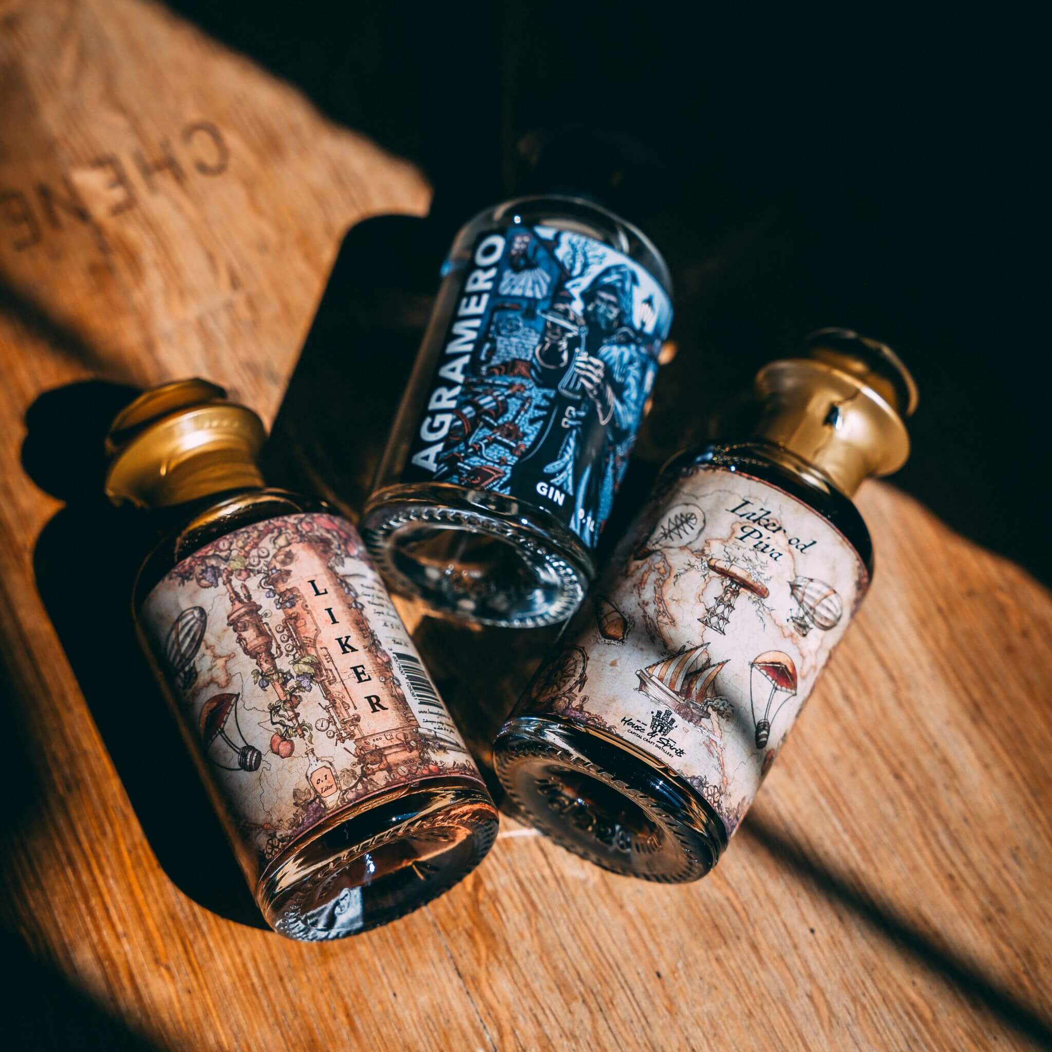 Three small bottles with decorative labels on a wooden surface